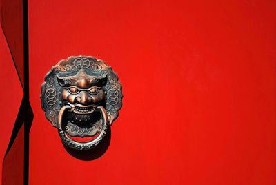 Close-up of statue against red wall