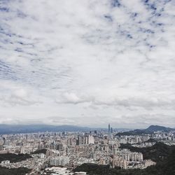 High angle view of cityscape against cloudy sky