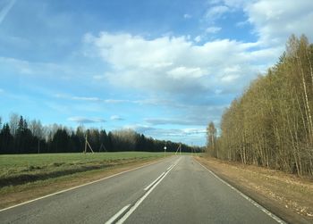 Road by trees against sky