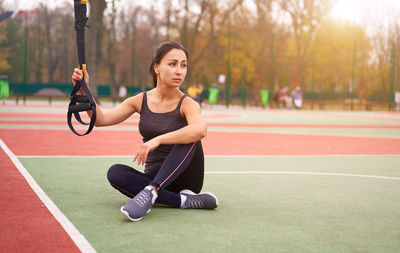 Full length of woman exercising on field