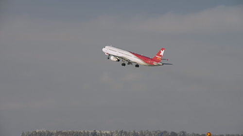 Low angle view of airplane flying against sky