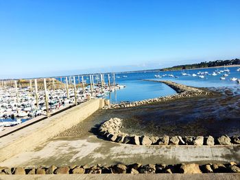 Pier over sea against clear blue sky