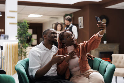 Young woman using mobile phone while sitting at home