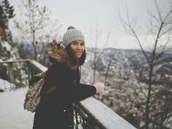 Portrait of smiling woman standing at balcony 