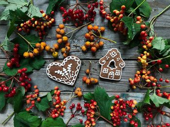 Directly above shot of gingerbread cookies and berries on wooden table