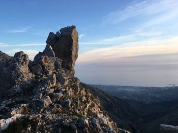 Rock formation against sky during sunset