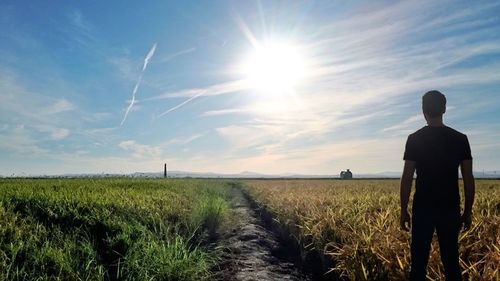 Rear view of people standing on field