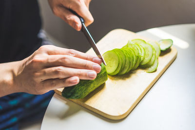 Midsection of person preparing food on cutting board