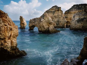 Rock formations on sea against sky