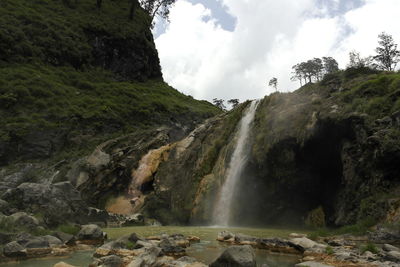 Scenic view of waterfall against sky