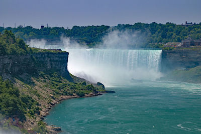 Scenic view of waterfall against sky