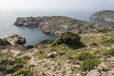 Scenic view of rocky mountains and sea against clear sky