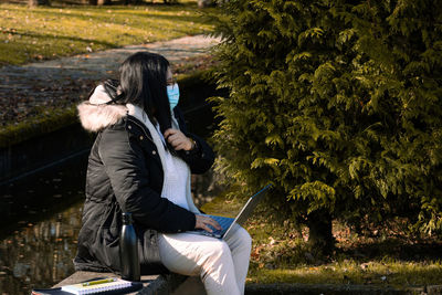 Rear view of woman sitting in park