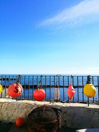 Umbrellas hanging by swimming pool against clear blue sky