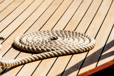 Rope neatly coiled on the wooden deck of a boat
