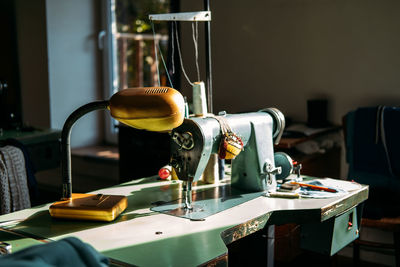 Sewing machine on table in factory in sun light. small business, fashion designe, tailor working, 