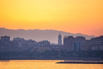 Buildings in city at sunset