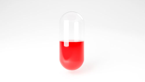 Close-up of red glass against white background
