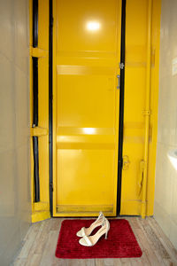 High angle view of yellow shoes on tiled floor at home