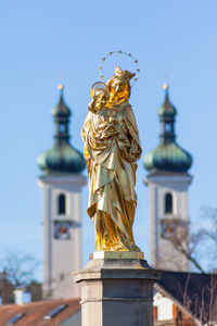Statue of angel against building against clear sky