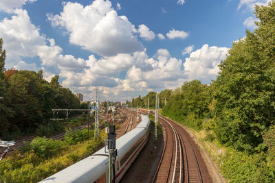 Railroad tracks amidst trees against sky