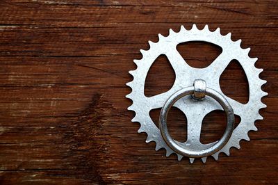 Close-up of wet metallic ring on gear over wood