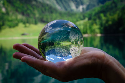 Cropped image of hand holding crystal ball