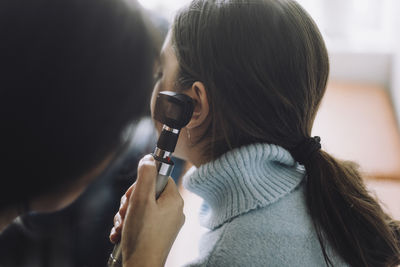 Girl wearing turtleneck undergoing hearing test at hospital