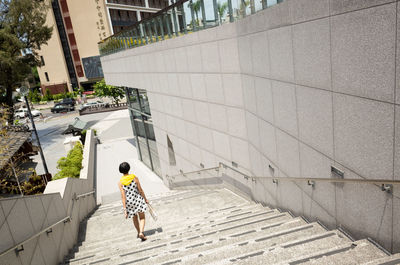 Rear view of woman walking on footpath