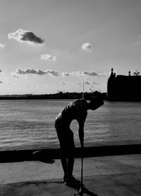 Silhouette woman standing on beach against sky