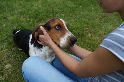 Midsection of woman with dog sitting on grass