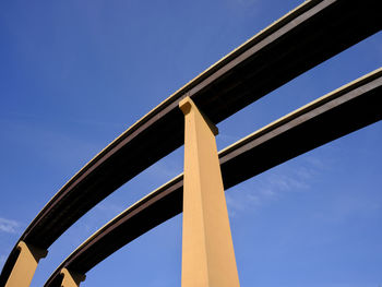 Low angle view of bridge against clear blue sky