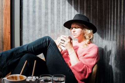 Woman sat looking at her coffee in a cafe