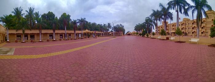 Panoramic shot of palm trees and buildings against sky