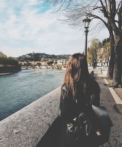 Woman standing by lake in city