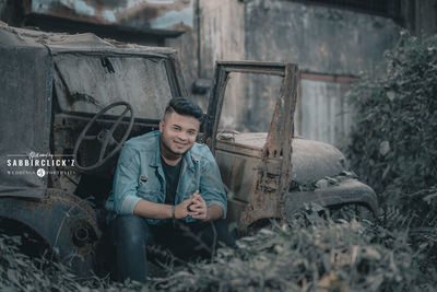 Portrait of young man sitting in abandoned building