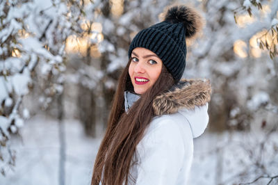 Young woman walking in the snowy winter day outdoor, winter forest landscape background