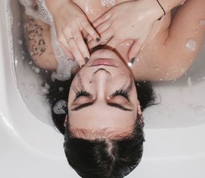 Portrait of woman lying down in bathroom