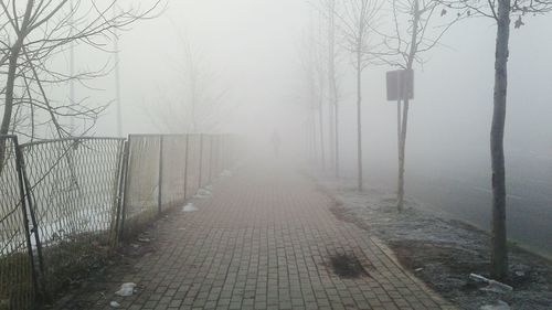 Snow covered landscape against sky during foggy weather