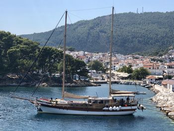 Sailboats in sea against city