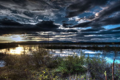 Scenic view of lake against cloudy sky