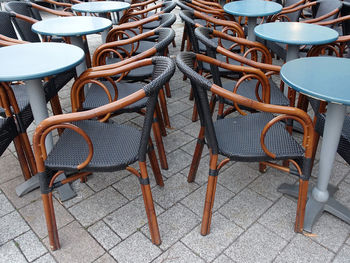Empty chairs and tables in front of the cafe on the street