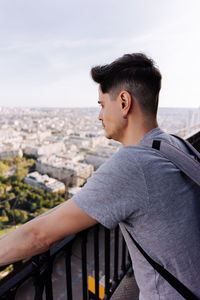 Side view of young man looking at cityscape