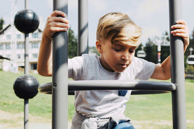 Small boy having fun while being on the playground at the park.