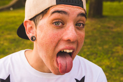 Close-up portrait of teenage boy sticking out tongue