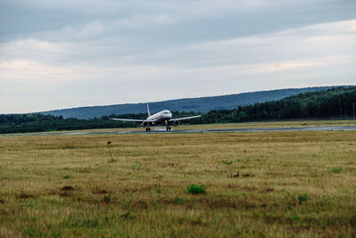 Airplane on field against sky