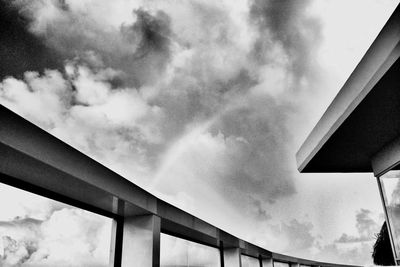 Low angle view of bridge against cloudy sky