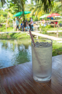 Close-up of drink on table by swimming pool