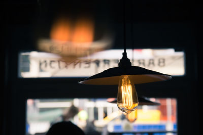 Close-up of lit light bulb against blurred background