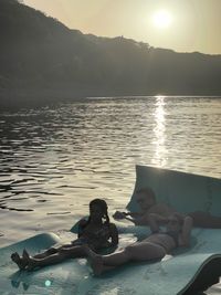 Woman relaxing in swimming pool against lake